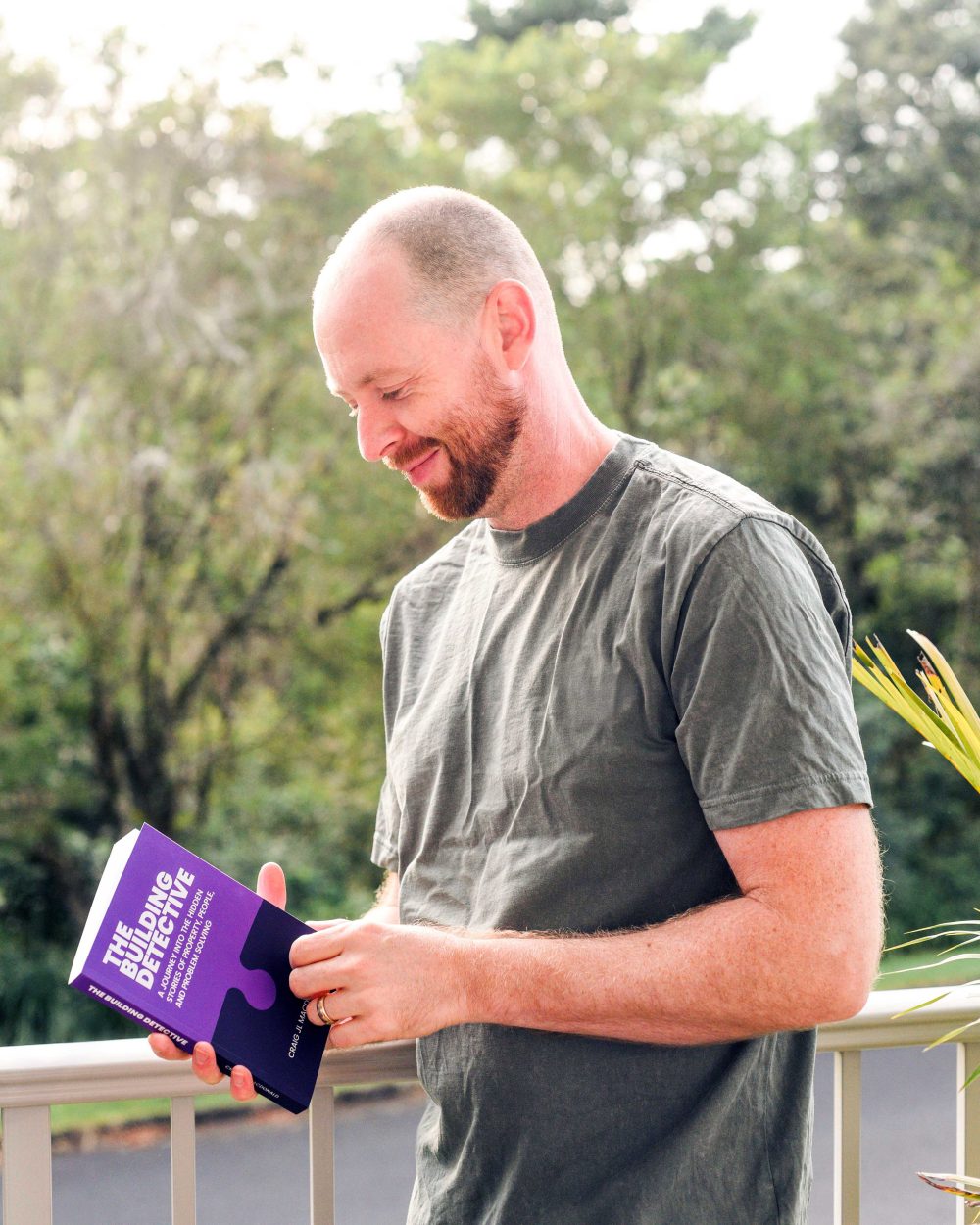 A reader with a copy of The Building Detective by Craig MacDonald
