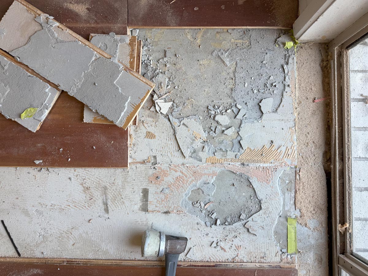 Defective engineered floorboards lifted, exposing failed adhesive