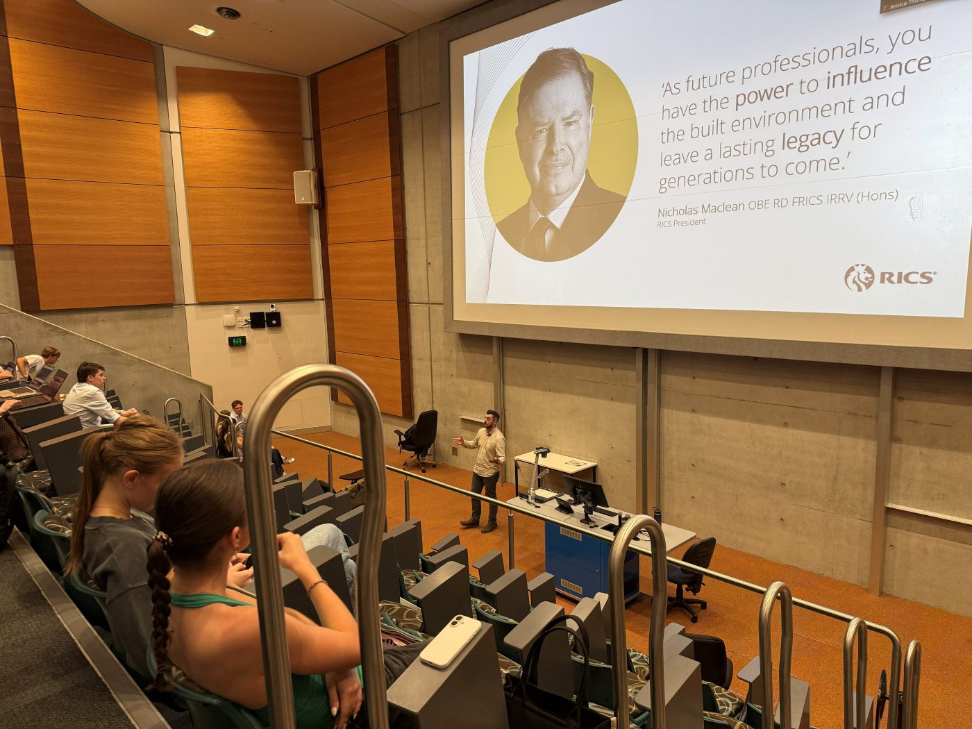 Craig MacDonald presenting an RICS talk to students in a university lecture theatre